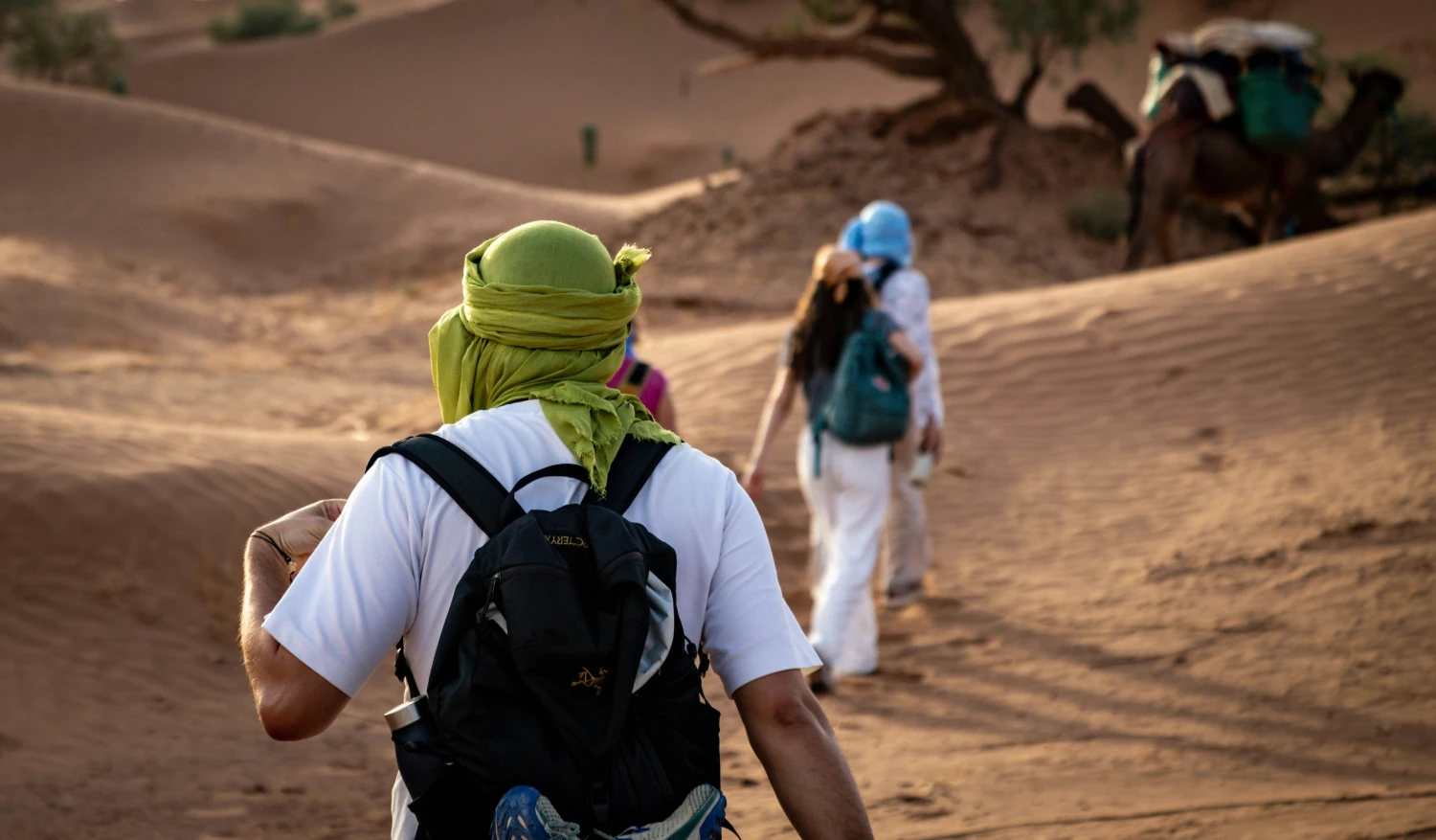 Travelers walking in the desert dunes